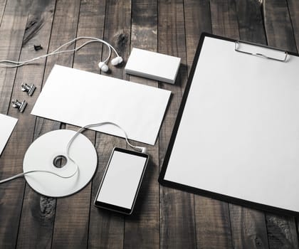 Blank corporate stationery set on wood table background.