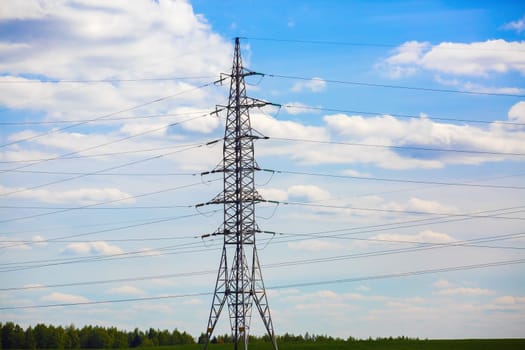High voltage post. High-voltage electricity pylon against blue sky.