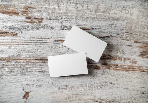 Blank business cards on wooden background. Mockup for branding identity. Studio shot. Flat lay.