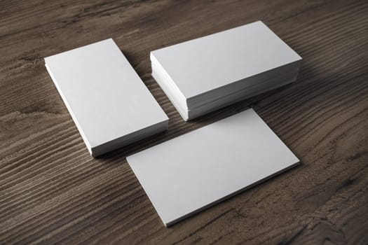 Blank business cards on wood table background. Template for branding identity.