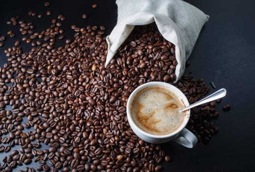 Photo of coffee cup, coffee beans and canvas bag.