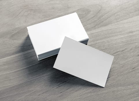 Blank white business cards on wood table background. Mockup for branding identity.