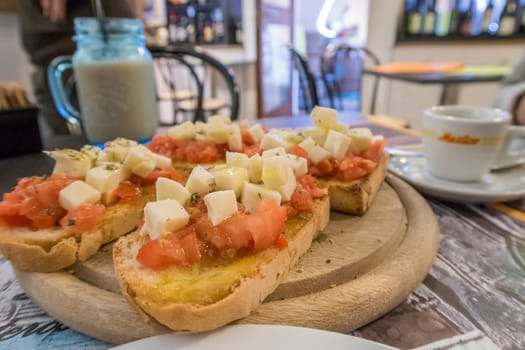 italian bruschetta with fresh tomatoes on wooden plank