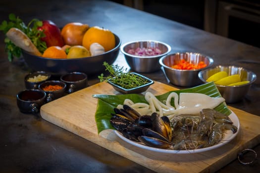 Raw seafood on plate with fruits and vegetables, healthy food, prawn, clam squid.
