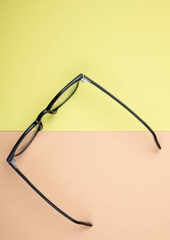 black glasses on yellow and orange ground from above