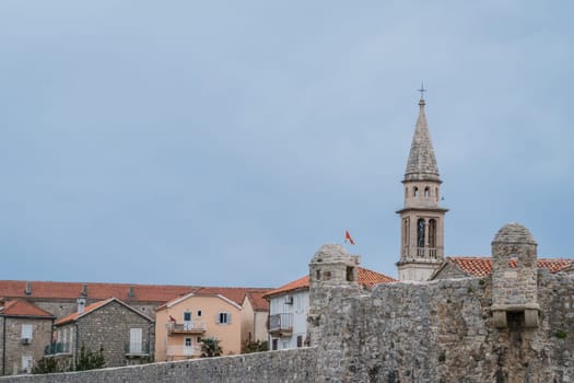 Budva, Montenegro - April 2018 : Church tower and high walls of the old town fort