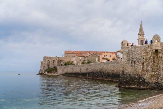 Budva, Montenegro - April 2018 : People sitting on the top of high walls of the old town fort