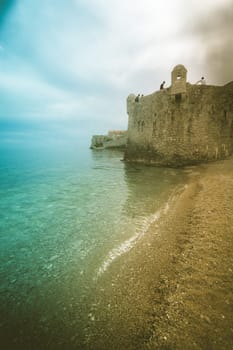 Budva, Montenegro - April 2018 : People sitting on the top of high walls of the old town fort