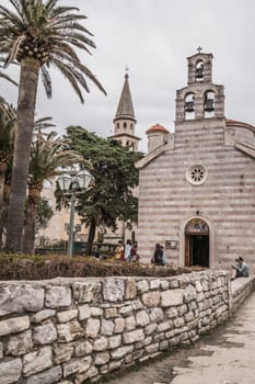 Budva, Montenegro - April 2018 : Courtyard and the three bells tower of the Church of Holy Trinity