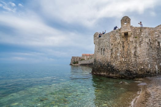 Budva, Montenegro - April 2018 : People sitting on the top of high walls of the old town fort