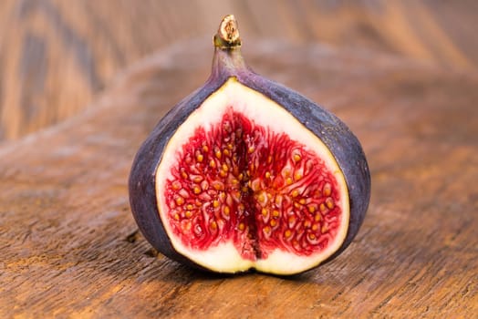 One sliced ripe, delicious and sweets figs on a old rustic wooden cutting board