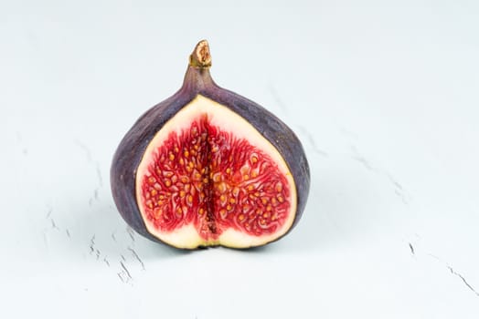 One whole wit a cutout ripe, delicious and sweets figs on a light blue vintage background
