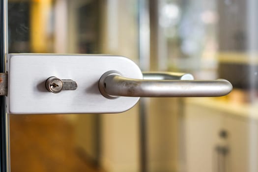 An abstract detail of a contemporary door handle for a glass door