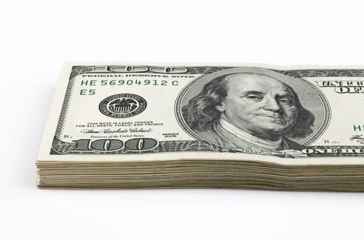 Part of a pack of one hundred dollar bills. View at an angle. Close-up. Isolated.