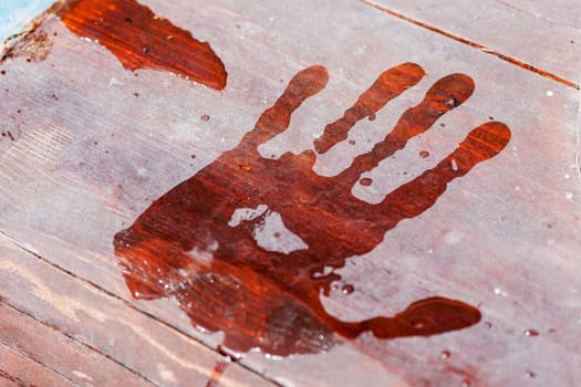 Close-up of a wet handprint on a wooden footbridge
