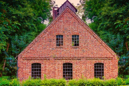 View of an old red brick factory building with narrow windows