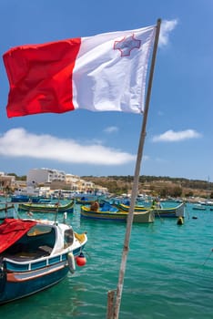 Flag of Malta waving in the wind in Marsaxlokk, Malta