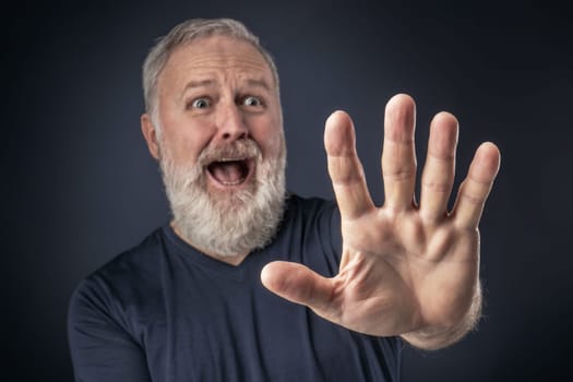 Old man in shirt and scared with his stretched hand forward