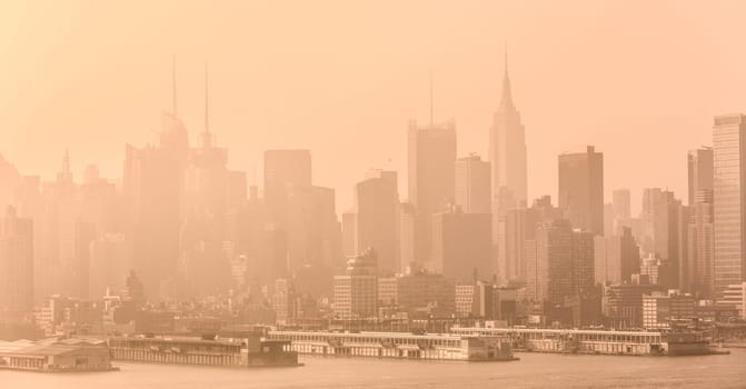 New York City midtown Manhattan skyline panorama view from Boulevard East Old Glory Park over Hudson River on a misty morning.