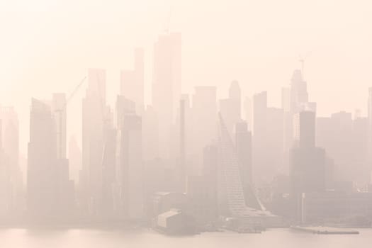 New York City midtown Manhattan skyline panorama view from Boulevard East Old Glory Park over Hudson River on a misty morning.