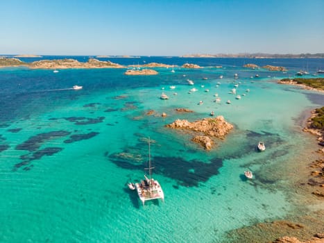 Drone aerial view of catamaran sailing boat in Maddalena Archipelago, Sardinia, Italy. Maddalena Archipelago is composed of Razzoli, Santa Maria and Budelli islands.