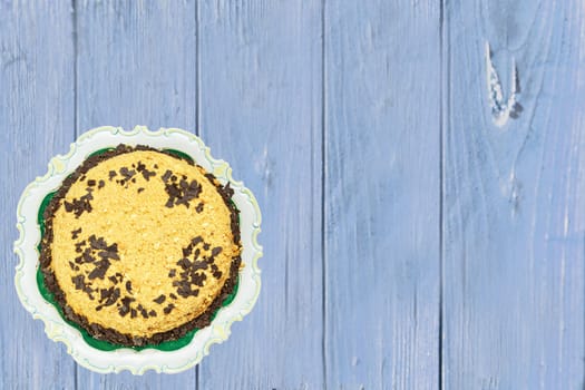 Top view of a beautiful Birthday cake on bright blue wooden table. Space for your product display montage and a number on the cake. Card concept.