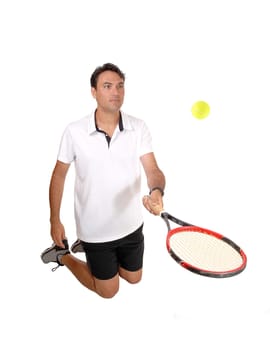 A happy young man kneeling on the floor playing with his racket and .yellow ball practising the game, isolated for white background.