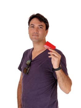 A surprised young man standing waist up and holding up.his credit card, spend to much, isolated for white background.