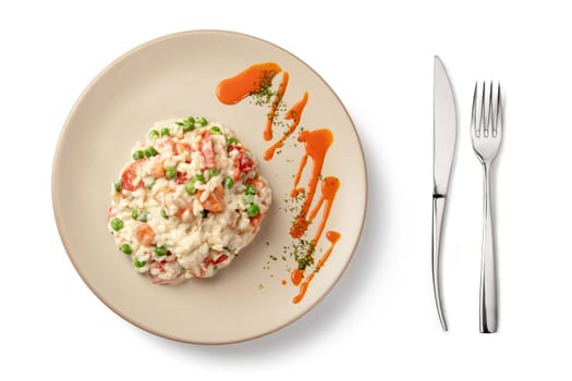 Plate and cutlery with risotto portion on white background