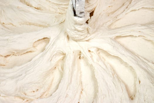 Dough kneading, mixed, in a professional mixer as background