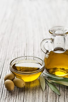 Bottle of Olive oil and green olives close up