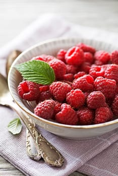 Raspberry berries with green leaf close up. Healthy food with fresh fruit.