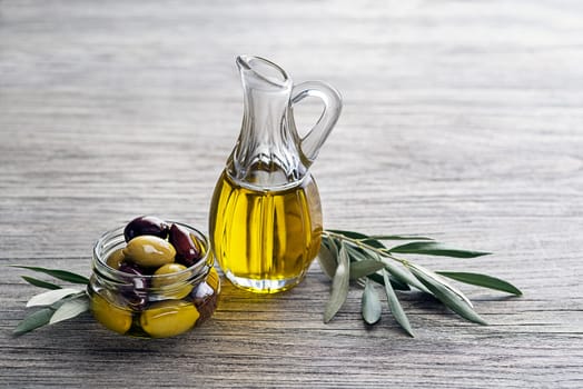 Bottle of Extra virgin healthy Olive oil with fresh olives on wooden background