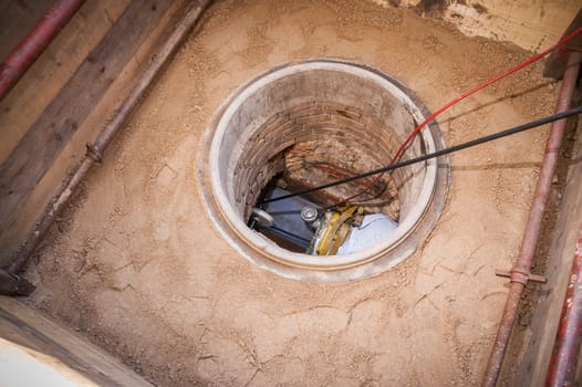 Rehabilitation work on an exposed sewer with manhole and automatic feed device for lining the canal.