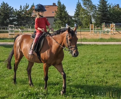 a little girl rides alone in the riding arena