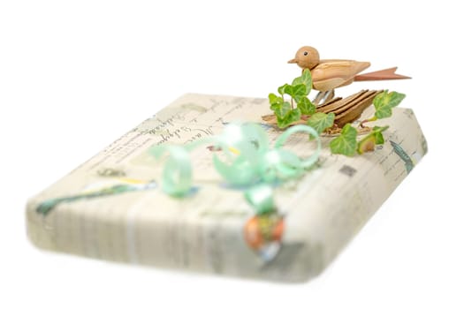 Bright gift box decorated with a wooden bird and bow isolated on white