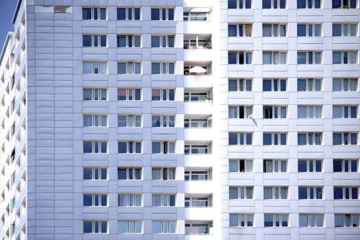 The window front of a skyscraper with apartments and balconies.