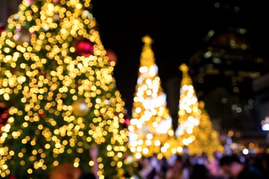 Conceptual background image of defocused abstract Christmas Tree on city street at night