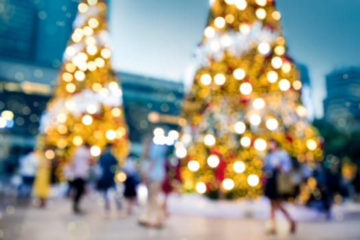 Conceptual defocused Christmas decoration and crowd of people on city street at night