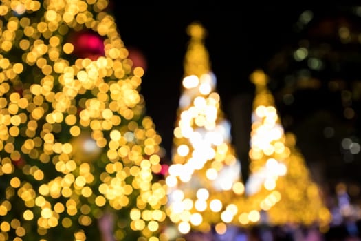 Conceptual background image of defocused abstract Christmas Tree on city street at night