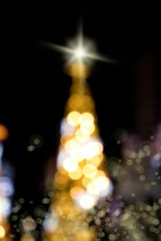 Conceptual background image of defocused abstract Christmas Tree on city street at night