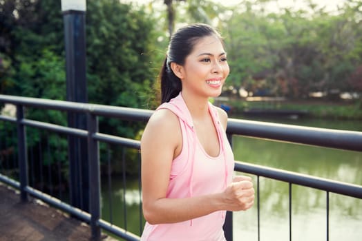 Happy asian athlete woman running on the park