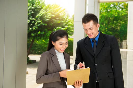 Young asian business people discussing business report at outside office room