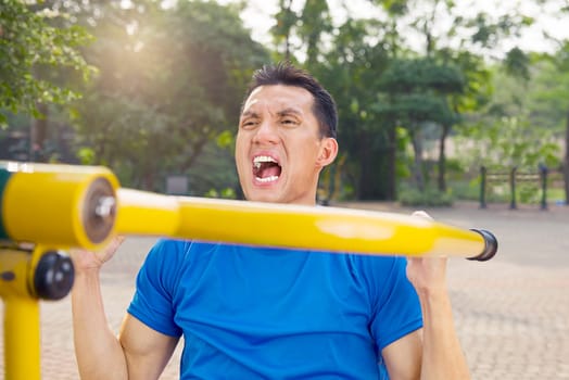 Attractive asian man doing working out at outdoor gym
