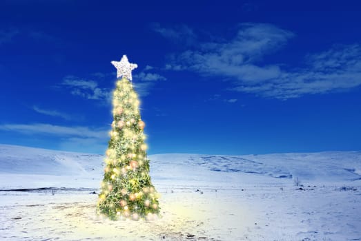 Conceptual image of decorated Christmas tree with colorful lights and ornaments on snow covered landscape