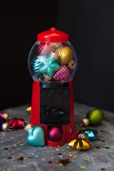 Colorful christmas baubles in bright colors in a chewing gum dispenser