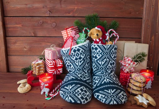Little knitted boots with christmas presents and various cookies
