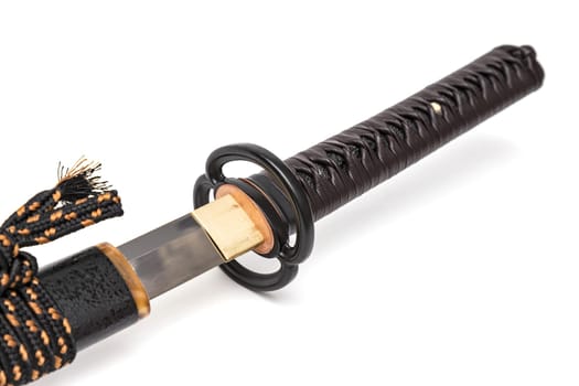 Brown leather cord tie on grip Japanese sword steel fitting and black scabbard on white background.