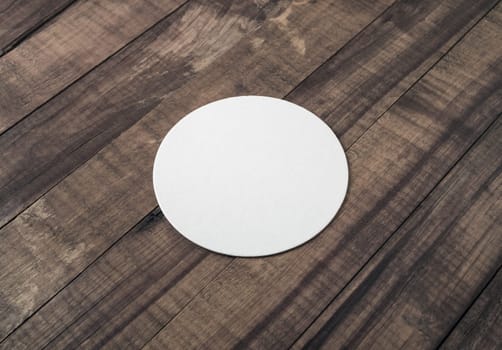 Blank beer coaster mockup on wood table background.