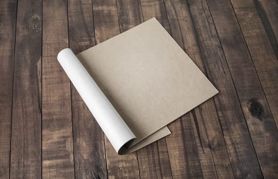 Blank notepad or brochure of kraft paper on vintage wooden background. Mockup for your design.